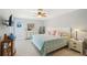 Light-filled bedroom features a ceiling fan, dresser with mirror, and comfortable queen bed with beach themed pillows at 467 Boca Ciega Point S Blvd, St Petersburg, FL 33708