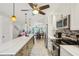 Modern kitchen featuring long breakfast bar, pendant lighting, and stainless steel appliances at 467 Boca Ciega Point S Blvd, St Petersburg, FL 33708
