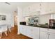 A modern kitchenette with white cabinets and granite countertops, connecting seamlessly to the living space at 4681 Carson Ne St, St Petersburg, FL 33703
