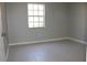 Vacant bedroom featuring tile flooring, neutral paint, a large window and a door at 4725 Joseph Ct # 233, Tampa, FL 33614