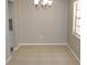 Unfurnished dining room highlighting tile flooring, neutral paint, chandelier and bright window at 4725 Joseph Ct # 233, Tampa, FL 33614