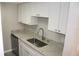 Well-lit kitchen with granite countertops, stainless steel sink, and white cabinetry at 4725 Joseph Ct # 233, Tampa, FL 33614