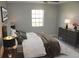 Staged main bedroom featuring modern furniture, a large window, decorative lamps and neutral paint at 4725 Joseph Ct # 233, Tampa, FL 33614