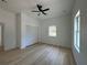 Bright bedroom featuring a ceiling fan, light-colored vinyl plank flooring, two windows, and closet space at 4920 72Nd N St, St Petersburg, FL 33709