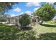 A lovely backyard features a screened-in pool, a healthy lawn, and beautiful, mature trees, creating a private oasis at 5042 Gaston St, Spring Hill, FL 34607