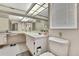 Bright bathroom with large mirror, sink, toilet, and tiled floor at 5042 Gaston St, Spring Hill, FL 34607