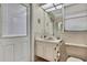 Cozy bathroom featuring a sink, toilet, mirror, and window with blinds at 5042 Gaston St, Spring Hill, FL 34607