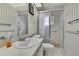 Bright bathroom featuring a glass shower stall, updated vanity and traditional style with striped wallpaper at 5042 Gaston St, Spring Hill, FL 34607