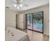 Bedroom with ceiling fan and sliding glass doors leading to an outdoor pool at 5042 Gaston St, Spring Hill, FL 34607