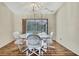 Bright dining area featuring a modern chandelier, hardwood floors, and access to the screened-in pool area at 5042 Gaston St, Spring Hill, FL 34607