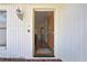 Inviting front entrance with a decorative wood door, brick accents, and a charming outdoor light fixture at 5042 Gaston St, Spring Hill, FL 34607