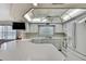 Well-lit kitchen featuring white appliances and cabinetry under a unique, bright ceiling fixture at 5042 Gaston St, Spring Hill, FL 34607