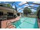 Beautiful backyard pool with screen enclosure, surrounded by a brick patio with outdoor seating at 5042 Gaston St, Spring Hill, FL 34607