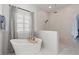 Serene bathroom featuring a soaking tub, a walk-in shower, and elegant design at 5043 Night Star Trl, Odessa, FL 33556