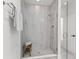 Modern bathroom with glass shower featuring tiled walls, showerhead, and a small wooden stool at 5043 Night Star Trl, Odessa, FL 33556