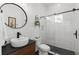 Modern bathroom features a stylish vanity, round mirror and a tiled walk-in shower with black hexagon tile floor at 5043 Night Star Trl, Odessa, FL 33556