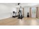 Bright workout room features an elliptical, treadmill, neutral walls, wood-look floors and natural lighting at 5043 Night Star Trl, Odessa, FL 33556