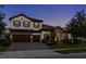 Charming two-story home at dusk with warm lighting and a well-maintained yard at 5043 Night Star Trl, Odessa, FL 33556