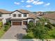 Stunning two-story home with a tile roof, a paved driveway, a manicured lawn, and a three-car garage at 5043 Night Star Trl, Odessa, FL 33556