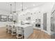 Modern, all-white kitchen with a large island, pendant lighting, and stainless steel appliances at 5043 Night Star Trl, Odessa, FL 33556