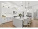 A bright, all-white kitchen features a large island with seating and modern stainless steel appliances at 5043 Night Star Trl, Odessa, FL 33556