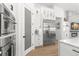 Modern kitchen with stainless steel appliances, white cabinetry, and beautiful wood floors at 5043 Night Star Trl, Odessa, FL 33556
