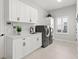 Well-equipped laundry room with modern appliances, cabinets, sink, and neutral color palette at 5043 Night Star Trl, Odessa, FL 33556