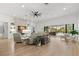 Open living room with fireplace, view to outdoor kitchen, and sliding glass doors to the pool at 5043 Night Star Trl, Odessa, FL 33556