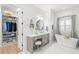 Bright bathroom featuring a soaking tub, dual vanities, and a spacious walk-in closet at 5043 Night Star Trl, Odessa, FL 33556