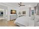 Airy main bedroom with wood floors, dresser, and a large TV for relaxing viewing at 5043 Night Star Trl, Odessa, FL 33556