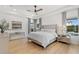 Bright main bedroom featuring tray ceilings, wood floors, and well-lit views to the backyard at 5043 Night Star Trl, Odessa, FL 33556