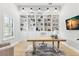 Bright office features custom built-ins, a large desk, and natural light from a window at 5043 Night Star Trl, Odessa, FL 33556