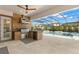 Covered outdoor kitchen with built-in grill, stainless steel appliances, and view of the pool at 5043 Night Star Trl, Odessa, FL 33556
