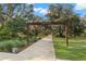 Entrance to Albritton Park showcasing a paved path and mature trees with Spanish moss at 5043 Night Star Trl, Odessa, FL 33556