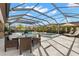 Beautiful screened-in pool and spa area with an umbrella table and lounge chairs at 5043 Night Star Trl, Odessa, FL 33556