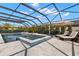 Screened-in pool and spa area with comfortable lounge chairs and lush landscaping at 5043 Night Star Trl, Odessa, FL 33556