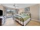 Bedroom features tile floors, queen bed, balcony access, and neutral decor at 5855 Midnight Pass Rd # 201, Sarasota, FL 34242