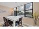 The dining area features a modern table and chairs, tile flooring, and a large window overlooking the outdoors at 5855 Midnight Pass Rd # 201, Sarasota, FL 34242