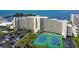 An aerial view of a condo complex, tennis courts, the bay, and neatly landscaped grounds at 6009 Sea Ranch Dr # 107E, Hudson, FL 34667