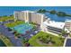 Aerial view of condo complex with tennis courts, parking and bay views at 6009 Sea Ranch Dr # 107E, Hudson, FL 34667