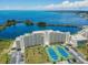 Panoramic aerial view of a waterfront condominium featuring tennis courts and stunning water views at 6009 Sea Ranch Dr # 107E, Hudson, FL 34667