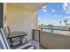 Relax on the balcony with a table and chairs, overlooking the pool and palm trees at 6009 Sea Ranch Dr # 107E, Hudson, FL 34667