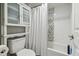 Clean bathroom featuring a toilet, white shower curtain, tiled walls, and a storage cabinet at 6009 Sea Ranch Dr # 107E, Hudson, FL 34667