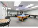 A bright game room showcasing a pool table, ping pong table, checkerboard, and shuffleboard at 6009 Sea Ranch Dr # 107E, Hudson, FL 34667