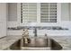 Close up of a stainless kitchen sink with granite countertops and a white backsplash at 6009 Sea Ranch Dr # 107E, Hudson, FL 34667