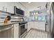 Modern kitchen with stainless steel appliances, white cabinetry, and wood-look tile flooring at 6009 Sea Ranch Dr # 107E, Hudson, FL 34667
