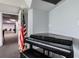 The room features a black piano, an American flag, and a door to a connecting room at 6009 Sea Ranch Dr # 107E, Hudson, FL 34667