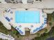 A top down view of a large in-ground swimming pool surrounded by lounge chairs and tables at 6009 Sea Ranch Dr # 107E, Hudson, FL 34667