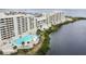 Aerial view of a large in-ground swimming pool with lounge chairs and tables for residents of the condo at 6009 Sea Ranch Dr # 107E, Hudson, FL 34667