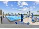 Community pool with chairs and tables for relaxing and enjoying beautiful views and clear, sunny skies at 6009 Sea Ranch Dr # 107E, Hudson, FL 34667